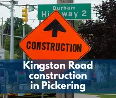 Orange diamond-shaped construction sign with a black arrow pointing straight ahead stands in front of a green “Durham Highway 2” road sign. Construction vehicles and roadside equipment are visible in the background. A blue banner overlay across the lower half of the image displays the text: “Kingston Road construction in Pickering.”